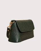 Side view of green croc-embossed handbag with zippered pocket and adjustable shoulder strap