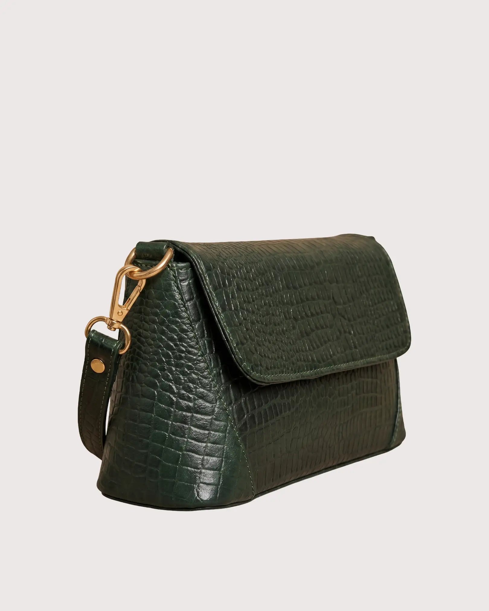 Side view of green croc-embossed handbag with zippered pocket and adjustable shoulder strap