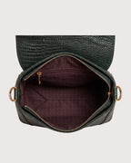 Interior of green croc-embossed purse featuring spacious compartment and secure storage pockets