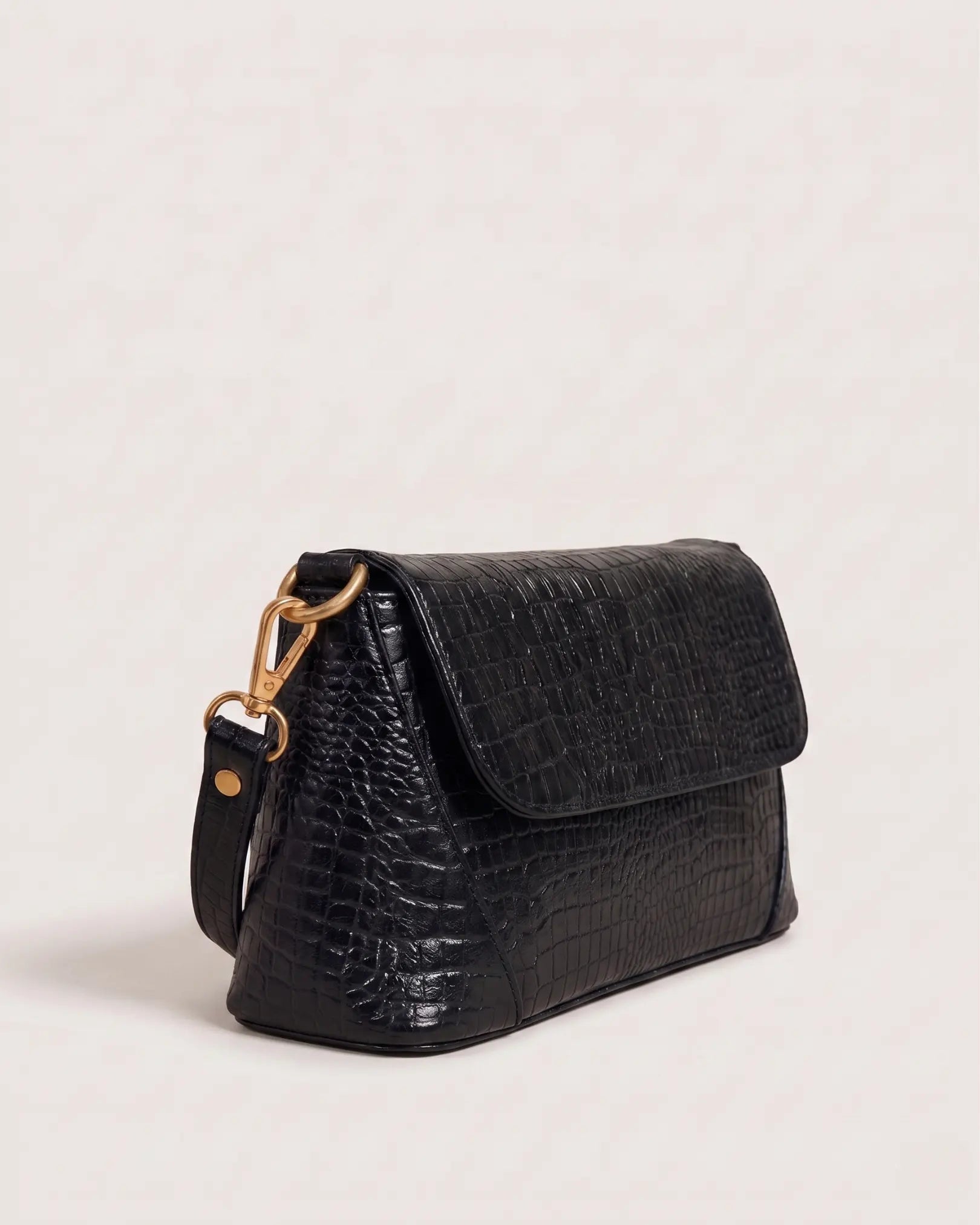 Side profile of black crocodile-texture handbag with adjustable strap and sleek structured design