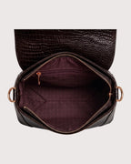 Interior of brown croc-embossed purse featuring spacious compartment and secure storage pockets